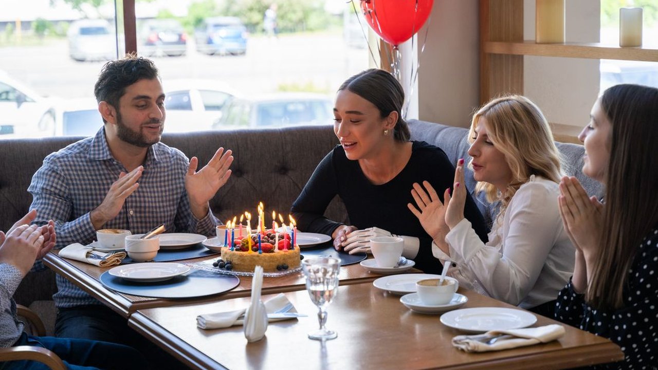 Friends celebrating a birthday around a restaurant table